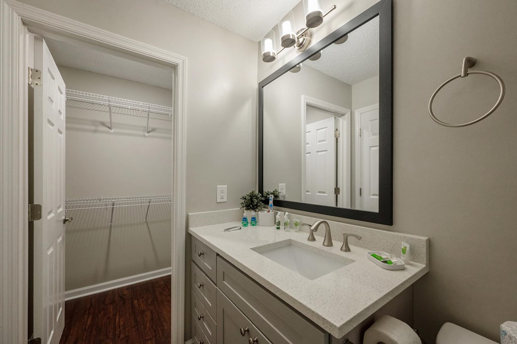 A bathroom with a sink, mirror, and a white door.