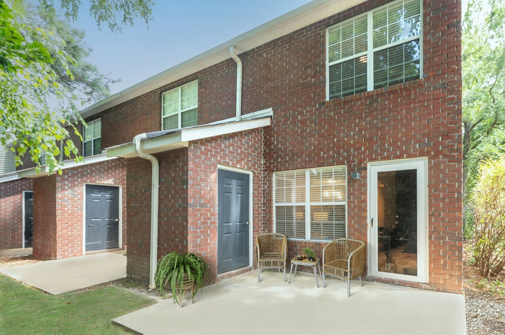 A red brick house with a white door and windows.