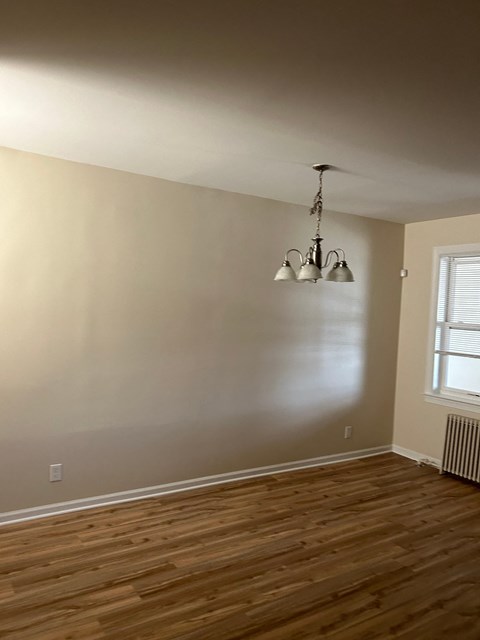 A room with wooden floors and a chandelier.