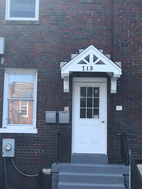 A white door with a black frame and a number 7113 above it.
