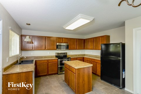 a kitchen with wooden cabinets and a black refrigerator