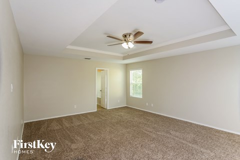 a living room with carpet and a ceiling fan