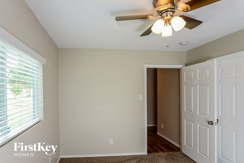 a bedroom with a ceiling fan and a door to a closet