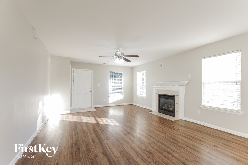 A spacious room with a fireplace and a ceiling fan.