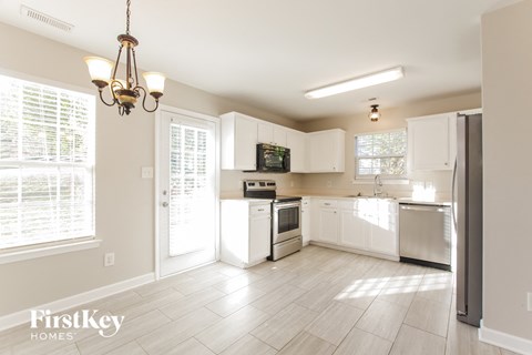 A kitchen with white appliances and cabinets is shown.