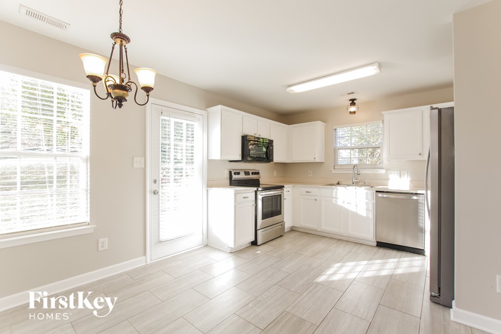 A kitchen with white appliances and cabinets is shown.