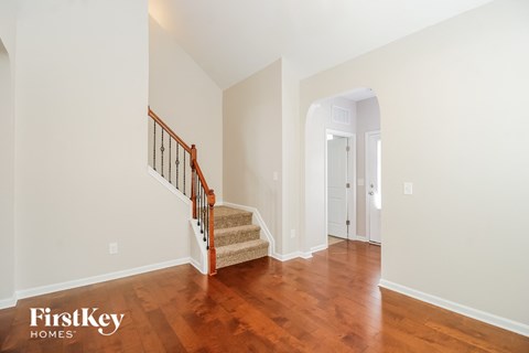 a renovated house with a staircase and a hallway with hardwood floors
