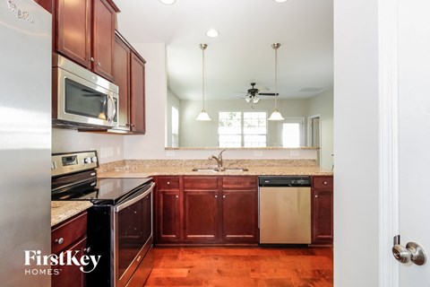 a kitchen with wooden cabinets and stainless steel appliances and granite counter tops