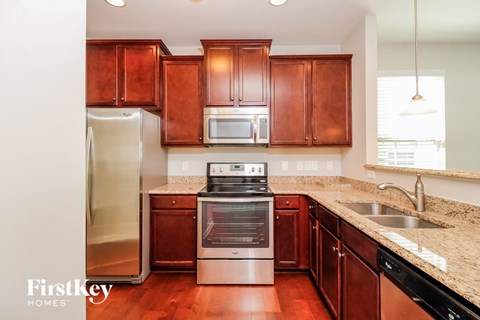a kitchen with wooden cabinets and stainless steel appliances and granite counter tops