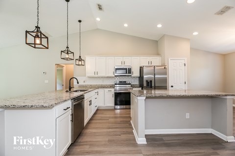 A kitchen with granite countertops and a center island.