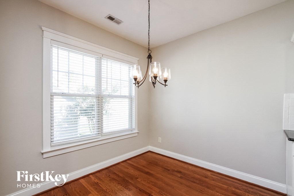 A room with a window and a chandelier hanging from the ceiling.