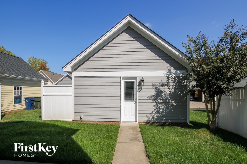 A small house with a grey roof and a white door is shown.