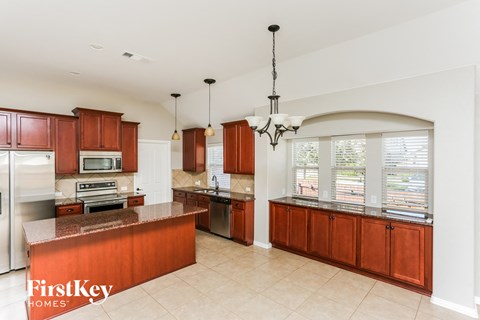 A kitchen with brown cabinets and a FirstKey Homes logo.