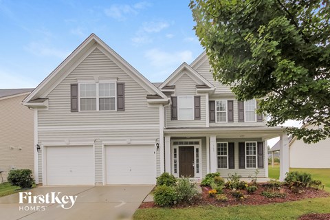 a white house with white shutters and a driveway