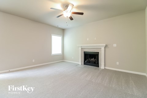 a living room with a fireplace and a ceiling fan