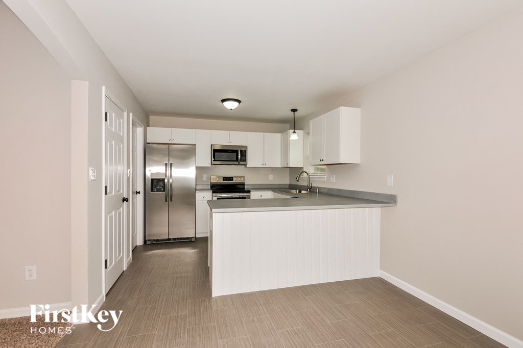 a large kitchen with white cabinets and stainless steel appliances