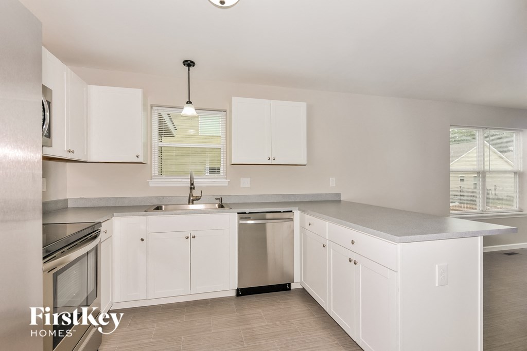 a white kitchen with white cabinets and stainless steel appliances