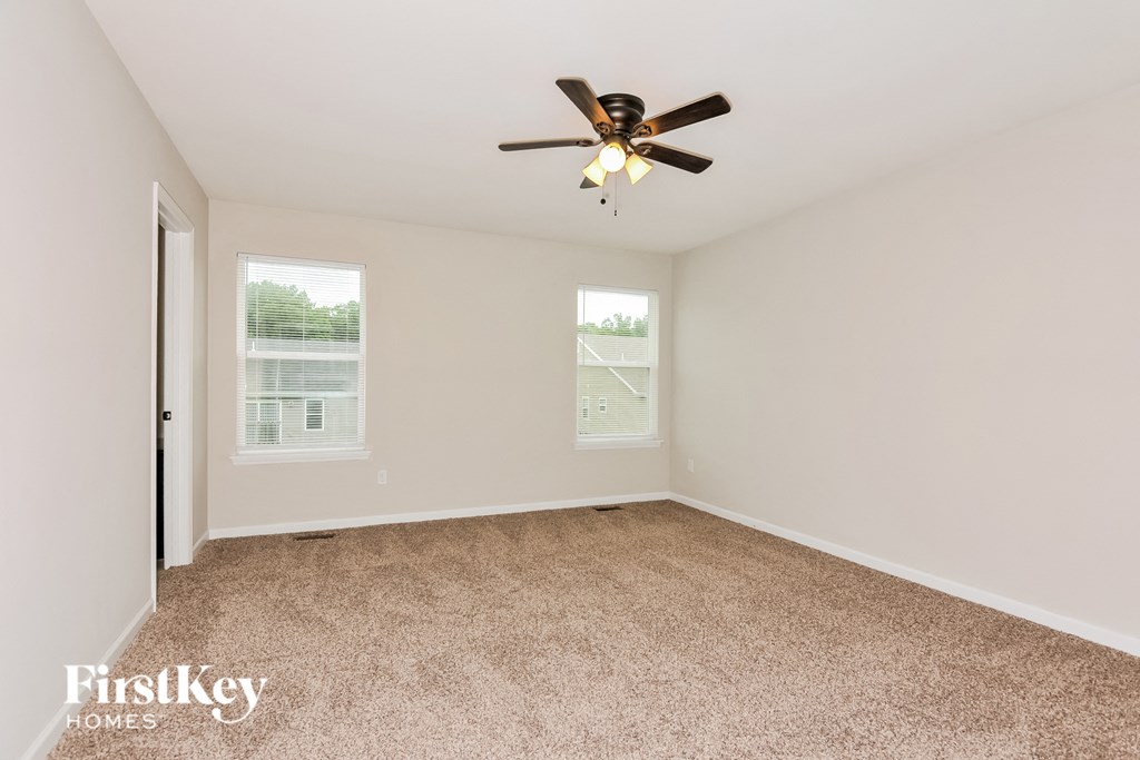 a bedroom with carpet and a ceiling fan