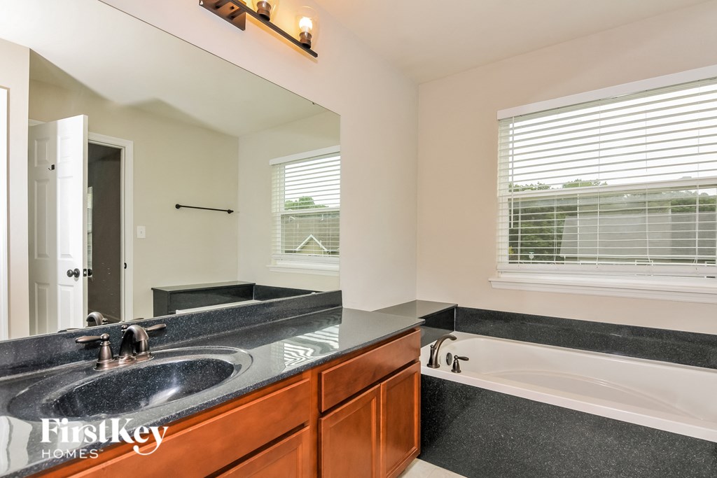a bathroom with a sink and a tub and a mirror