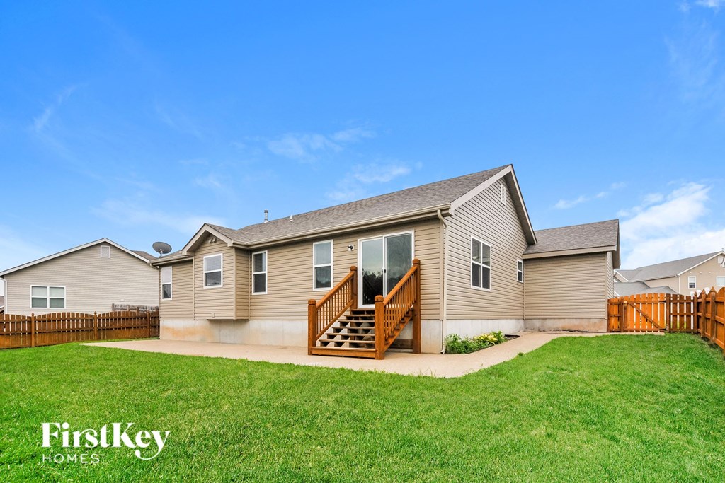 a beige house with a fisheye view of the yard and grass