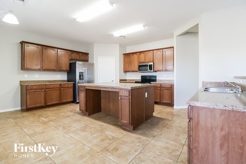 A kitchen with brown cabinets and a tile floor.