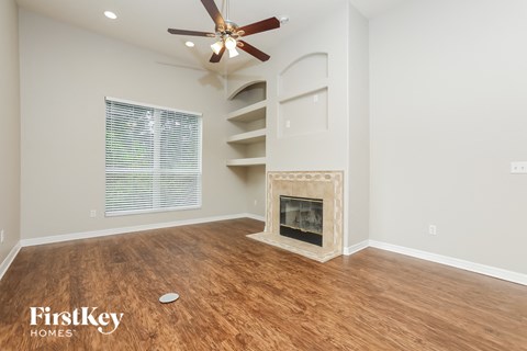 a living room with a fireplace and a ceiling fan