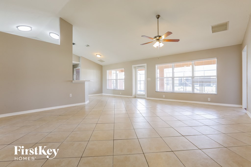 A spacious room with a fan and tile flooring.