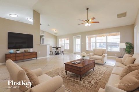 A living room with a brown coffee table and beige couches.