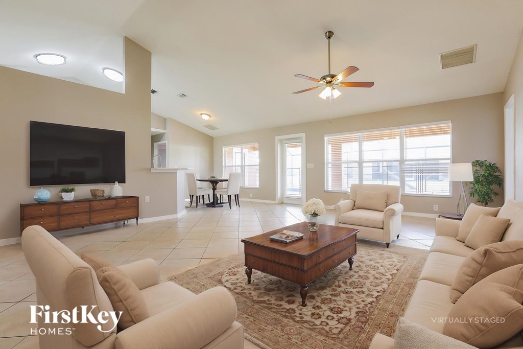 A living room with a flat screen TV, a coffee table, and a rug.