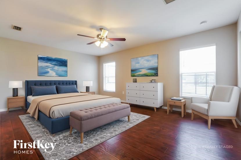 A bedroom with a bed, dresser, and chair.