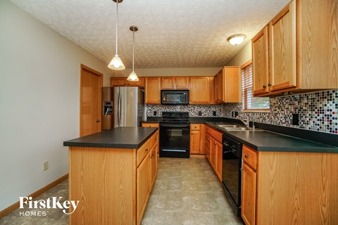 a kitchen with wood cabinets and black counters and a black counter top