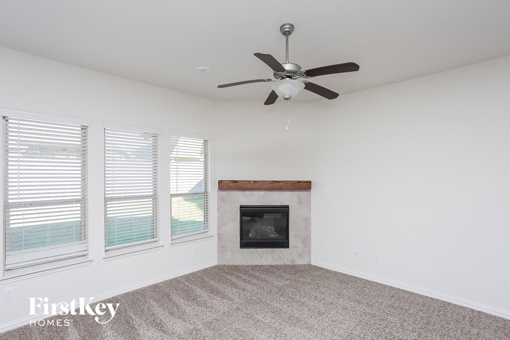 a living room with a fireplace and a ceiling fan
