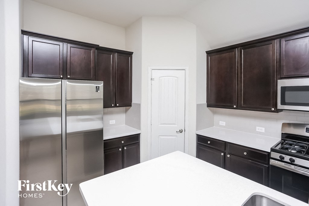 a kitchen with stainless steel appliances and white counter tops