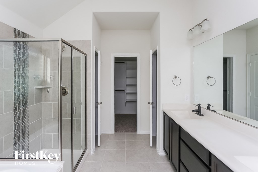 a bathroom with a shower and a sink and a mirror