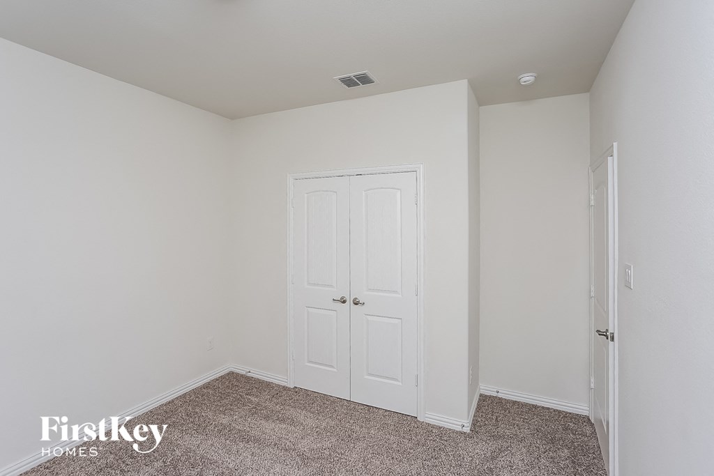 a bedroom with a white door and a carpeted floor