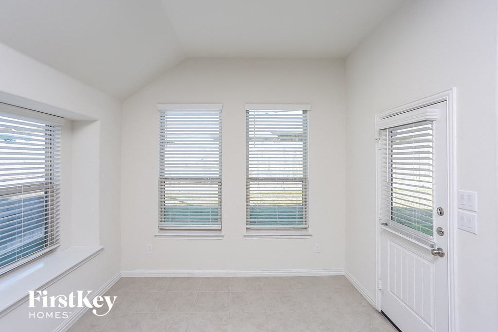 a bedroom with three windows and a door to a balcony