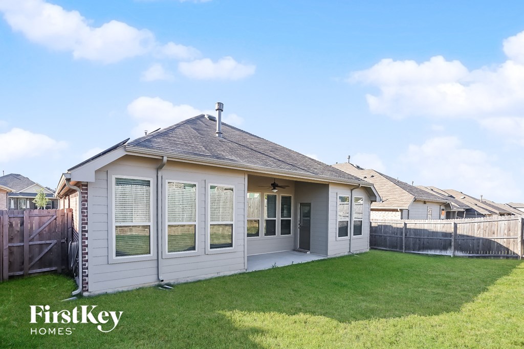 a small white house with a yard and a fence
