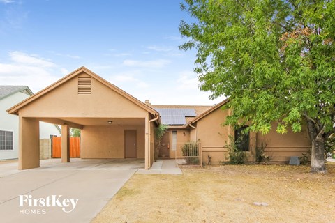 A house with a brown roof and a tree in front of it.