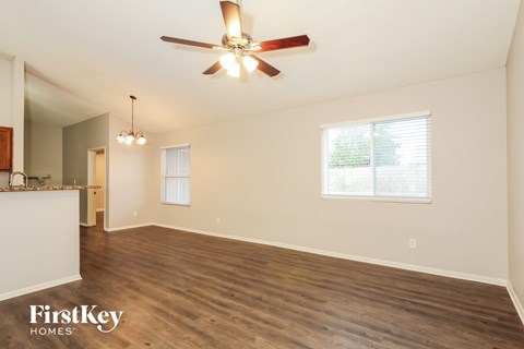 A spacious room with a ceiling fan and wooden flooring.