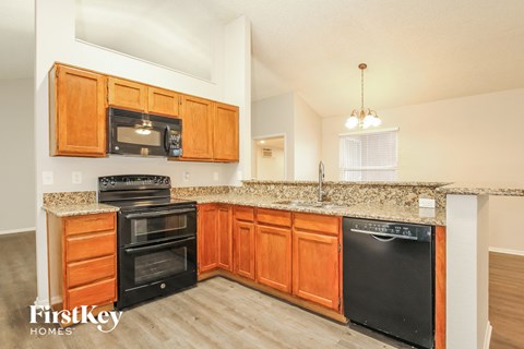 A kitchen with wooden cabinets and black appliances.