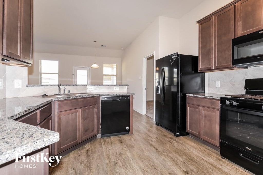 a kitchen with wooden cabinets and black appliances