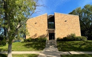 a large brick building with a tree in front of it