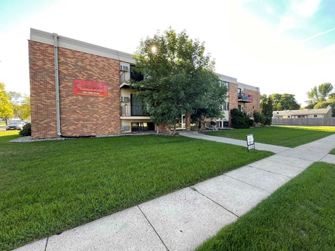 a sidewalk in front of a brick building