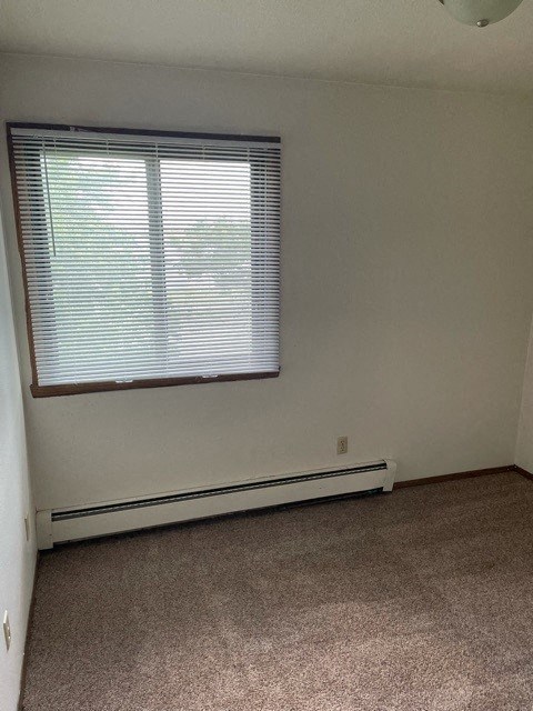 an empty room with a window and a carpet