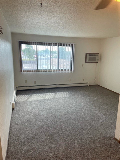 an empty room with a window and a carpet floor