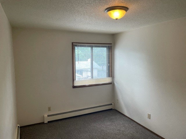 an empty room with a window and a ceiling light