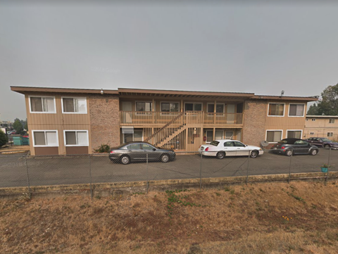 an apartment building with cars parked in front of it