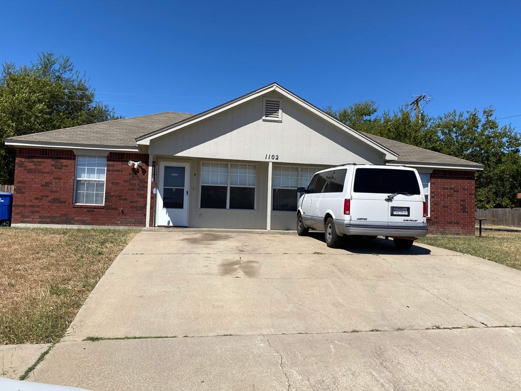 a white van parked in front of a brick house
