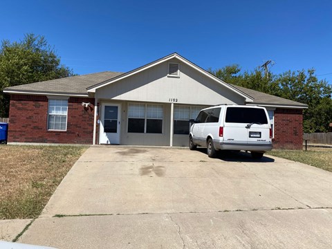 a white van parked in front of a brick house