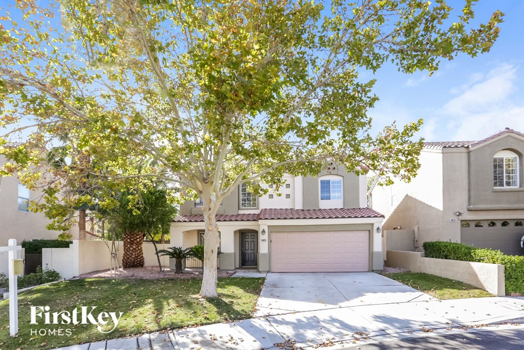 a house with a driveway and a tree in front of it